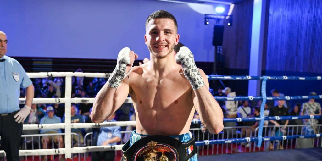 Ibrahim Boukedim pose devant les photographes avec sa ceinture de champion de France.